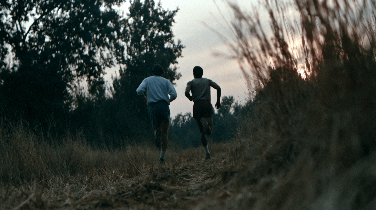 Two people running together on a trail at dusk